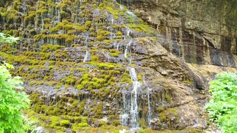 Scenic waterfall flowing over mossy rocks in Bezengi Gorge Stock Footage 338013461