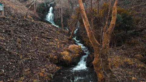 A Scenic Waterfall Tumbles Down a Rocky Hillside - Pullback Shot Stock Footage 304090906
