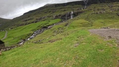 Scenic wide view of a cascading waterfall and stream in Saksun, Faroe Islands Stock Footage 339383286