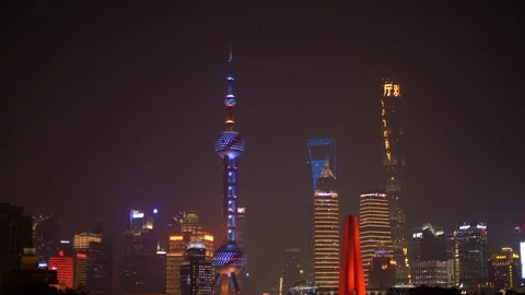 Scenically Lit Shanghai Skyline Reflected in the Water at Night Tilt Down 4k Stock Footage 123046424