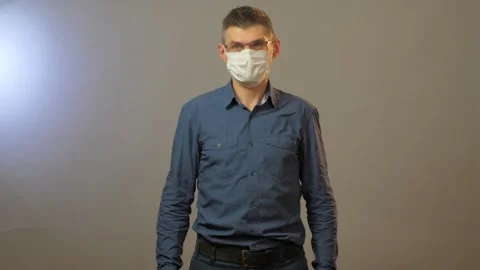 Sceptic guy takes disposable mask off and throws away Stock Footage 135390934