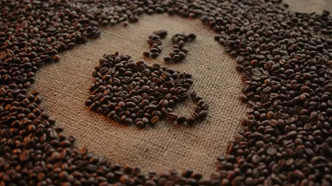 Schematic drawing coffee cup made of roasted coffee beans on burlap surface Stock Footage 135638365