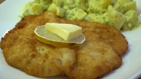 Schnitzel, crispy fried chicken, lemon and butter with potatoe salad, rotating Vídeos de archivo 69841582