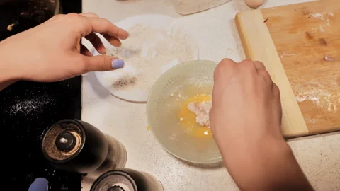 Schnitzel Preparation Scene in Cluttered Kitchen With Hands Breading Chicken Stock Footage 310546679