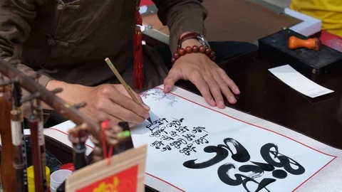 Scholar writes Vietnamese calligraphy characters on street Stock Footage 103189409