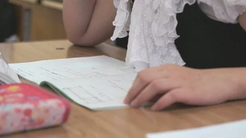 Schoogirl writes text in a notebook on a lesson Stock Footage 70145559