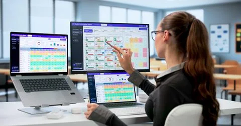 School Administrator Uses Software On Laptop To Track Student Grades. Stock Photos