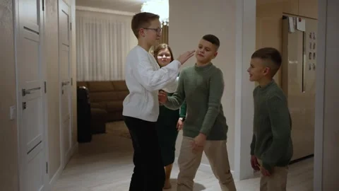 A school-age boy greets his friends whom he came to visit Stock Footage 260572304