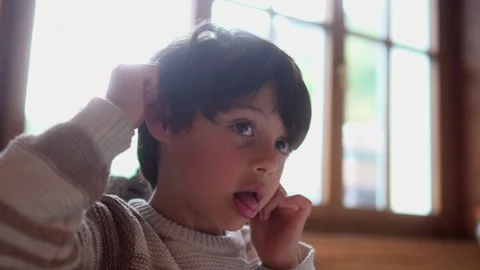 School age boy makes funny faces while waiting at restaurant table, capturi.. Stock Footage 340976604