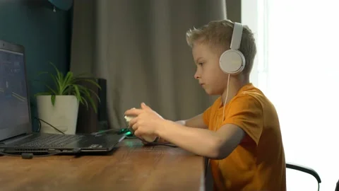 A school-age boy plays computer games at home Stock Footage 194468736