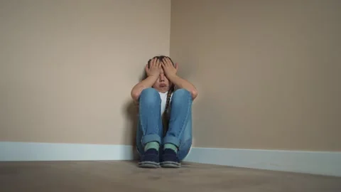 School-age child is sad in corner of room. Sad, crying child offended. girl is Stockbeeldmateriaal 252109287