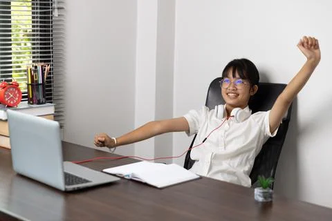 School age student doing her homework with digital tablet at home, child us.. Stock Photos
