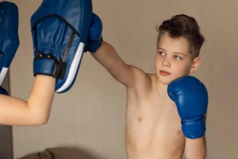 A school-aged boy is boxing at home during quarantine. Sport is not a hindran 库存照片