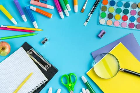 School background, a frame of various office supplies on a blue background. Stock Photos