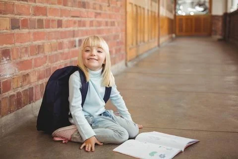 School backpack and open workbook are resting on polished concrete floor near Stock Photos