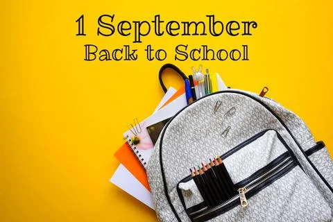 School Backpack with Colored Pencils Notebooks and Pens on Yellow Background Stock Photos