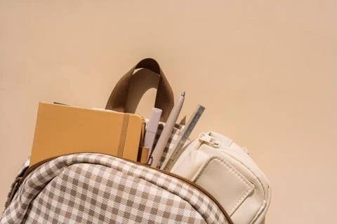 School backpack filled with notebooks, pens and pencil case in warm sunlight Stock Photos