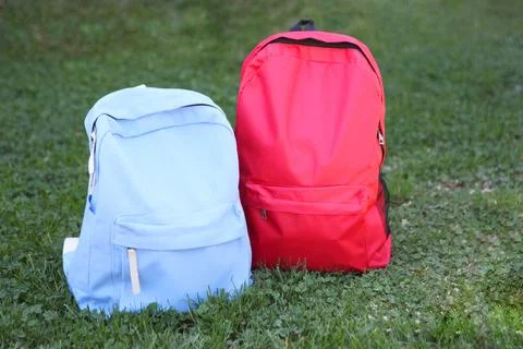 School backpack on the grass outside Stock-Fotos