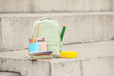 School backpack with notebooks, calculator, pencils, ruler, and lunchbox on c Stock Photos