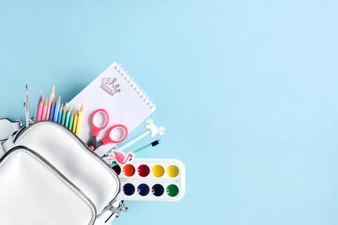 School backpack with stationery on a blue background top view. Back to school Stock Photos