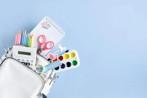 School backpack with stationery on a blue background top view. Back to school Stock Photos