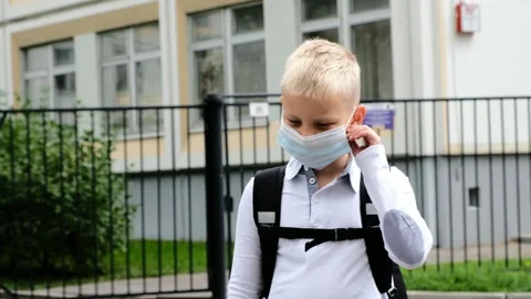 School boy child staying at school and taking off the medical mask. Back to Stock Footage 157439930