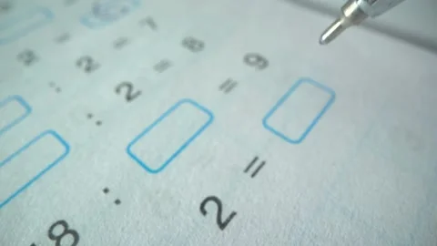 School boy decides examples math , education exam concept. Macro shot Stockbeeldmateriaal 141368779