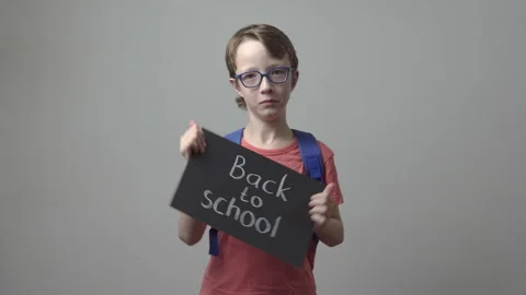 School boy in glasses is holding chalkboard. Back to school Stockbeeldmateriaal 339514232
