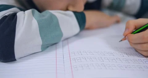 School boy practicing writing the alphabet at home Stock Footage 167795137