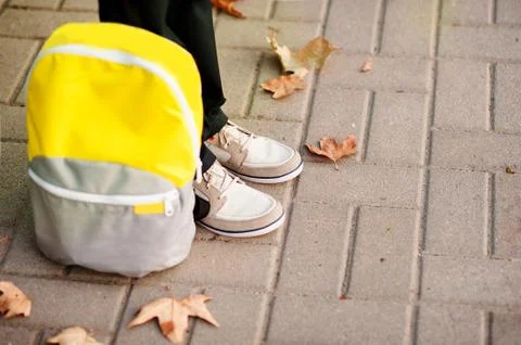 The school boy is ready to go to school. The legs are on the sidewalk, the Stock Photos