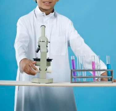 School boy using a microscope with chemicals in test tubes 스톡 사진
