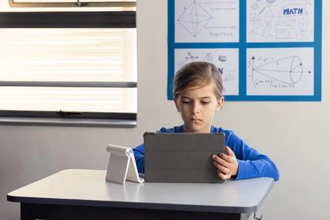 In school, boy using tablet for studying math in classroom Stock Photos