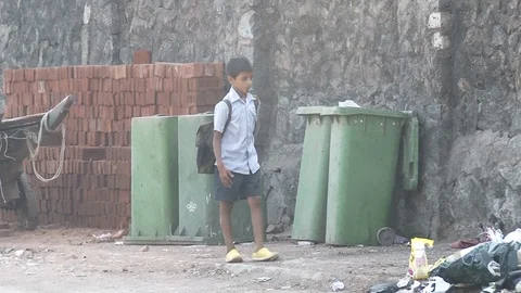 A SCHOOL BOY WALKS NEXT TO GARBAGE DUMP Stock Footage 130162404