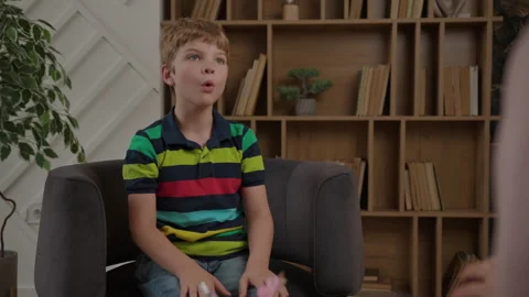 School boy working with speech therapist sitting on armchair. Children speech Stock Footage 211375885
