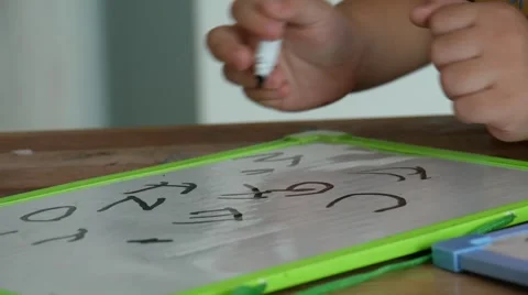 School boy writing a few math equations on a white board at room 스톡 동영상 65716036