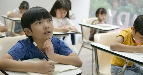 School boy writing on his notebook in the classroom. Video stock 112568338