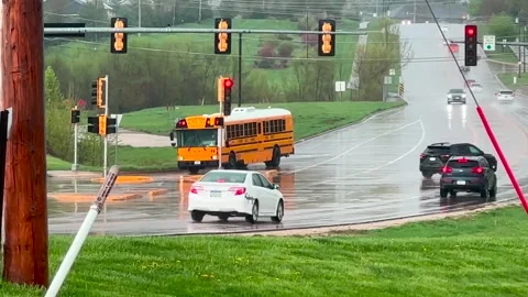 School Bus Pulls out into Street During Rain storm - Bettendorf, IA - 4/26/24 Stock Footage 274100489