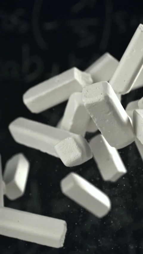 School chalk flies against the background of the blackboard. Filmed on a high Stock Footage 335376391