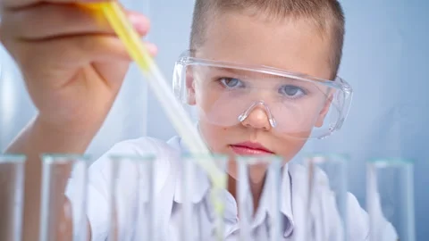 School, chemistry class. This boy was learning about liquids. Stock Footage 282902279