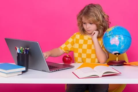 School child using laptop computer. School child 7-8 years old with book go back Stock Photos