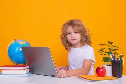 School child using laptop computer. School child studying in classroom at Fotos Stock