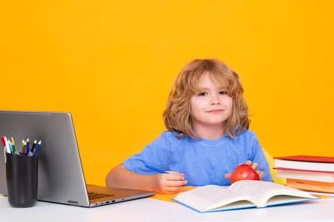 School child using laptop computer. Nerd school kid isolated on studio Stock Photos