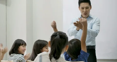 School children answer questions in class. Video stock 112574804