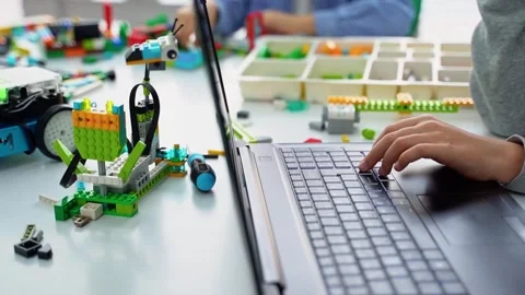School Children construct and code Robot. STEM education using laptop, remote Stock Footage 242293096