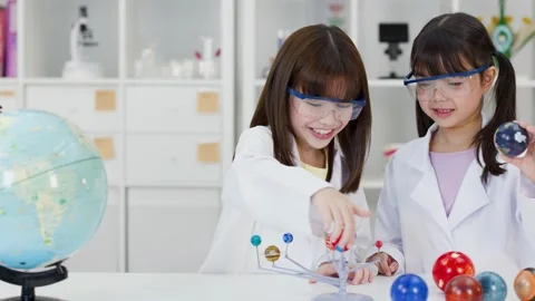 School Children in Lab Coats Studying Solar System Model in Classroom Stock Footage 340775278