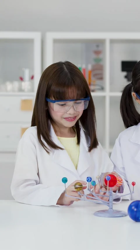 School Children in Lab Coats Studying Solar System Model in Classroom Stock Footage 346282479