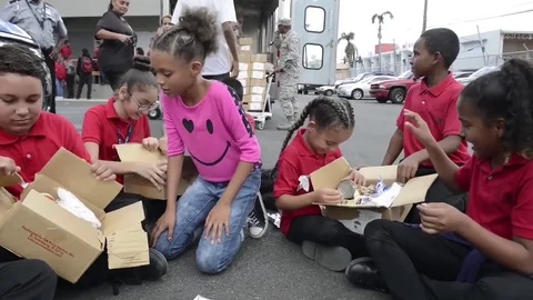 School children opening boxes of food from supply mission after Hurricane Maria Stock Footage 83683553