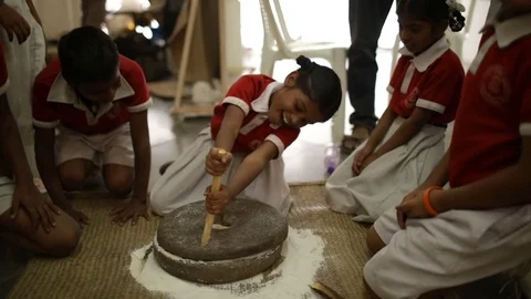 School children playing with stone mill grinder Slow Motion Stock Footage 85333050