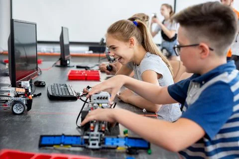 School children programs a robot in the classroom. 库存照片