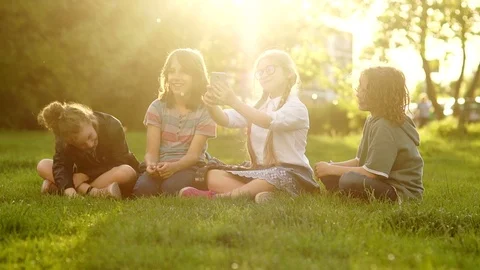 School children sit on the grass during a school break. Beautiful girl with Stock Footage 111518901